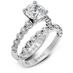 This marvelous white gold wedding set highlights its center stone with 1.19 ctw of round white diamond accents.