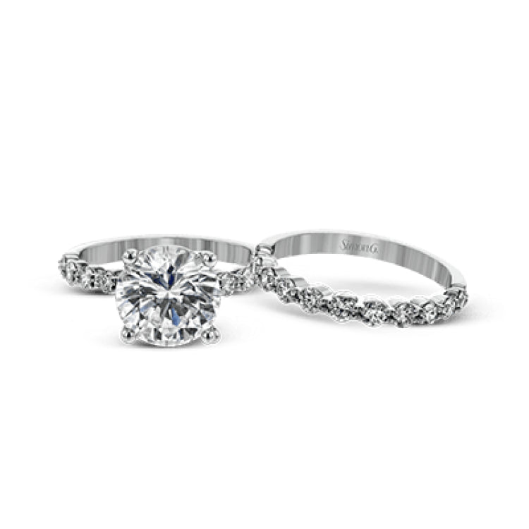 This marvelous white gold wedding set highlights its center stone with 1.19 ctw of round white diamond accents.