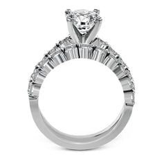 This marvelous white gold wedding set highlights its center stone with 1.19 ctw of round white diamond accents.