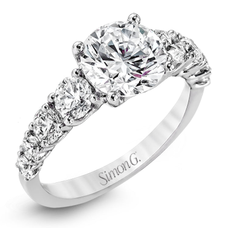 This white gold engagement ring's sophisticated, contemporary design glitters with 1.14 ctw of round white diamonds flanking the center stone.