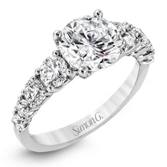 This white gold engagement ring's sophisticated, contemporary design glitters with 1.14 ctw of round white diamonds flanking the center stone.