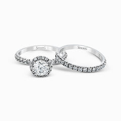 The classic halo design of this white gold engagement ring and wedding band are elevated by .80 ctw of shimmering round cut white diamonds.