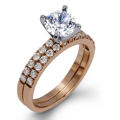 Featuring a modern take on a classic design, this white gold engagement ring and wedding band are inset with .58 ctw of glimmering round cut white diamonds.