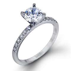 Featuring a modern take on a classic design, this white gold engagement ring and wedding band are inset with .58 ctw of glimmering round cut white diamonds.
