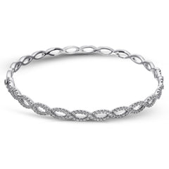 These simple twisted 18k gold bangle is the perfect accent piece. It can be worn alone or stacked with others, and has 1.12 ctw of white diamonds.