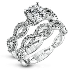 The intricate twisted design of this modern white gold engagement ring and wedding band set is set with .65 ctw of striking round cut white diamonds.