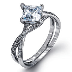 This dramatic white gold engagement ring and wedding band set are highlighted by .23 ctw of dazzling round cut white diamonds in a distinctive modern twist design.