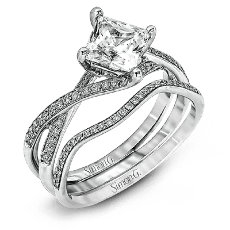 This dramatic white gold engagement ring and wedding band set are highlighted by .23 ctw of dazzling round cut white diamonds in a distinctive modern twist design.