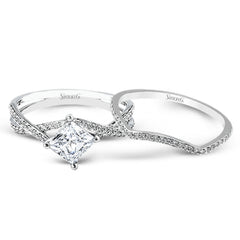 This dramatic white gold engagement ring and wedding band set are highlighted by .23 ctw of dazzling round cut white diamonds in a distinctive modern twist design.