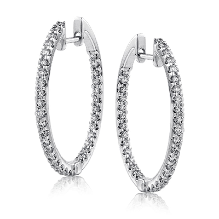 Featuring a classic hoop style, these white gold earrings are accented with .85 ctw of gleaming round cut white diamonds.