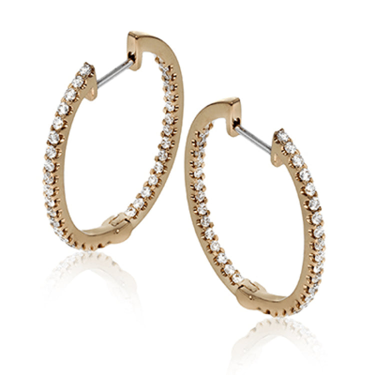 Featuring a classic hoop style, these white gold earrings are accented with .85 ctw of gleaming round cut white diamonds.