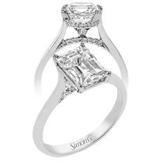 This elegant white gold engagement ring takes an Emerald center and is adorned with a delicate under halo, and a line of diamonds on the side profile 0.13 ctw