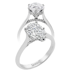 This elegant white gold engagement ring takes a pear shape center and is adorned with a delicate under halo, and a line of diamonds on the side profile 0.13 ctw