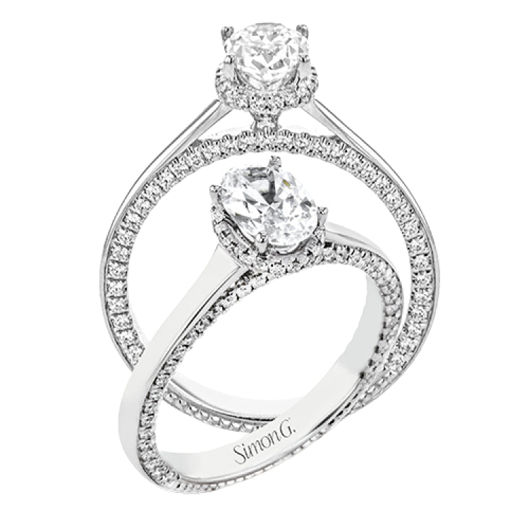 This engagement ring is made from an oval center stone and features a low halo as well as diamonds extended down the sides of the ring.