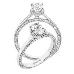 This engagement ring is made from an oval center stone and features a low halo as well as diamonds extended down the sides of the ring.