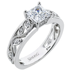 A delicate floral design highlights this vintage style engagement ring accented by .09 ctw of shimmering round cut white diamonds.