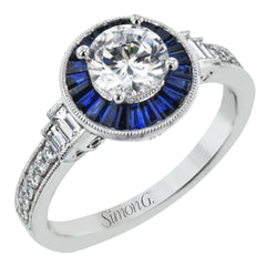 This 18k white gold engagement ring add something special with .46 ctw of baguette sapphires in a halo around the center stone. A total of .13 ctw of white diamonds and an additional .13 ctw of baguette diamonds finish this remarkable design.